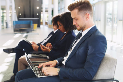 Businesswoman using laptop while sitting in office