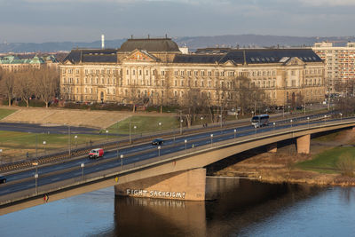 Bridge over river in city against sky