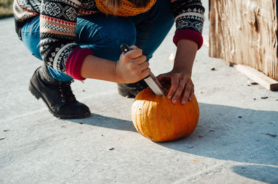 Midsection of man holding pumpkin