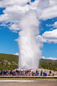 Rear view of man standing by fountain against sky