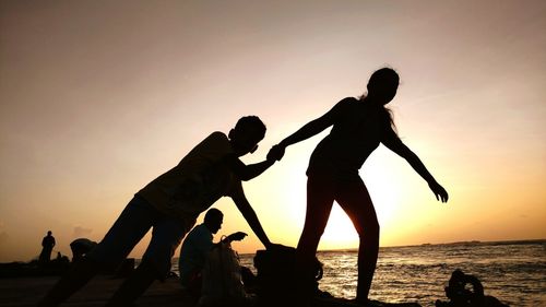 Silhouette of people enjoying on beach