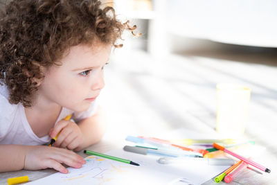 Boy drawing on book at home