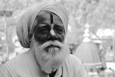 Portrait of old man with beard sitting outdoors