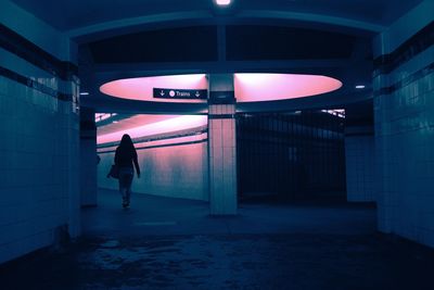 Rear view full length of woman walking in underground walkway