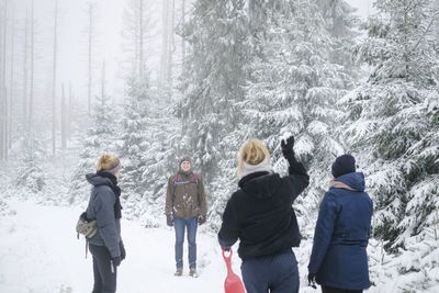 Rear view of people walking on snow covered land