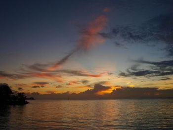 Scenic view of sea against cloudy sky at sunset