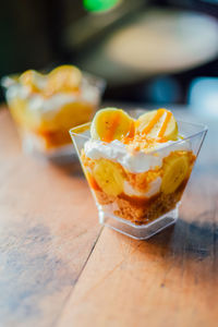 Two banoffee cake with caramelize bananas in cup on wood table,sweet homemade