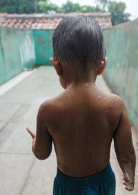 Rear view of shirtless boy in swimming pool