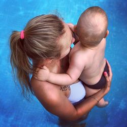 Midsection of mother and daughter in swimming pool