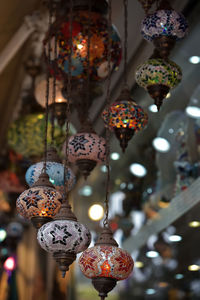 Close-up of illuminated lanterns hanging at market stall