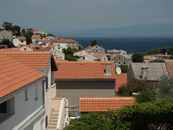 High angle view of townscape by sea against sky