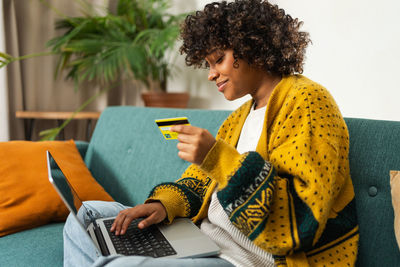 Midsection of man using digital tablet while sitting on table