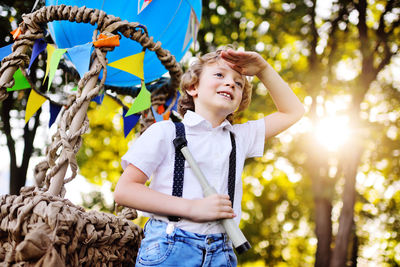 Boy holding binoculars standing in front of hot air balloon