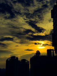 Silhouette city against sky during sunset