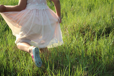 Low section of girl running on grass 