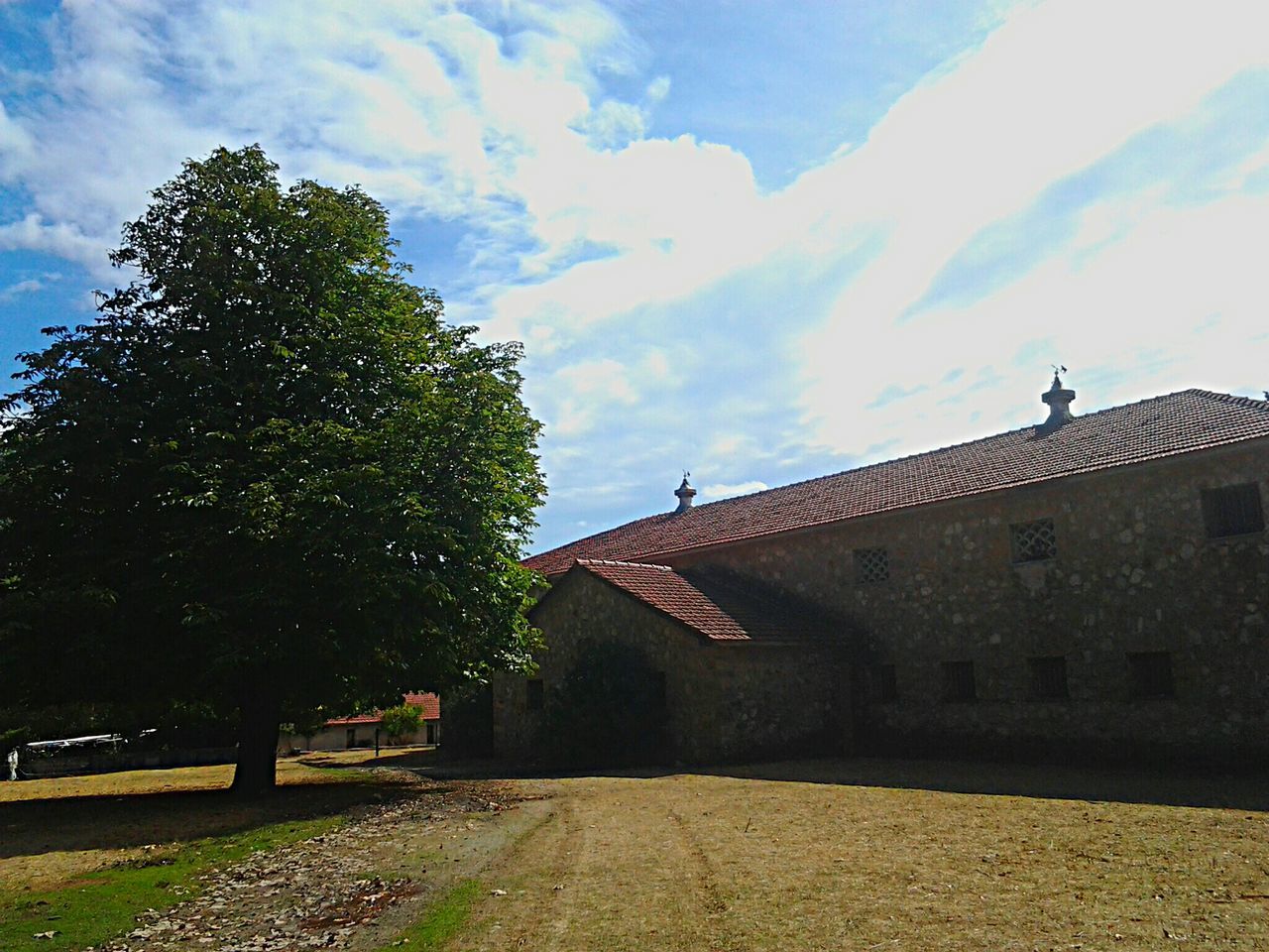 architecture, building exterior, built structure, the way forward, sky, house, tree, cloud - sky, street, residential structure, road, residential building, outdoors, day, cloud, roof, diminishing perspective, no people, vanishing point, sunlight