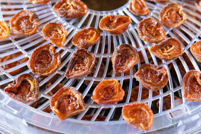 The process of home cooking dried fruits or candied fruit in an electric dryer on a rustic table. 