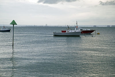 Fishing boat in sea against sky