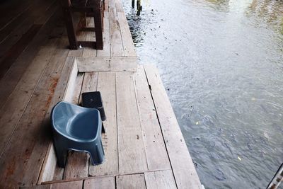 High angle view of coffee cup on pier over lake