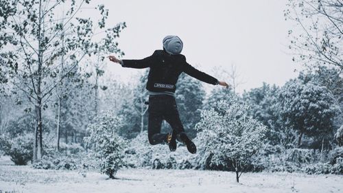 Full length of man jumping in snow