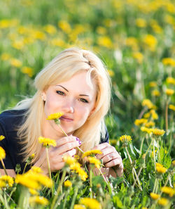 Portrait of young woman with flowers in field