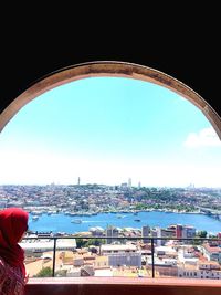 Man and woman against sea and cityscape against clear sky