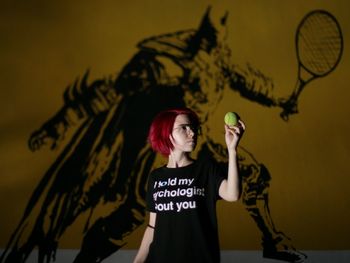 Portrait of young woman against wall