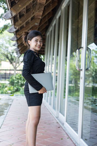 Woman in a black dress holds a laptop computer. the concept of young entrepreneurs.