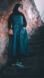 Midsection of woman standing against wall