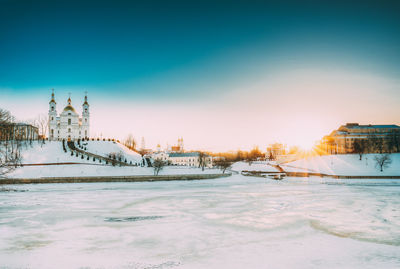 View of frozen river in city during winter