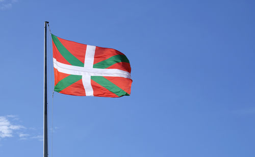 Low angle view of flag against clear blue sky