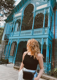 Rear view of woman standing against building