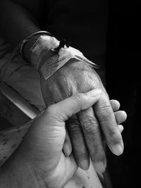 Cropped image of woman holding grandmother hand with iv infusion