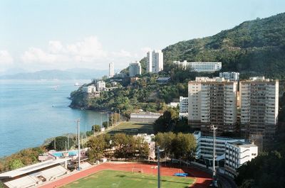 High angle view of buildings by sea against sky