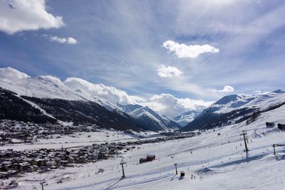 Scenic view of snowcapped mountain against cloudy sky