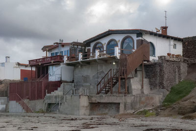 Old building by bridge against sky