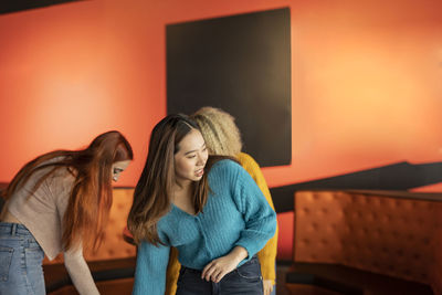 Women picking up ball at bowling alley