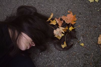 High angle view of woman with flowers on leaves