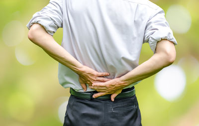 Midsection of man suffering from backache