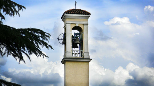 Low angle view of bell tower against cloudy sky