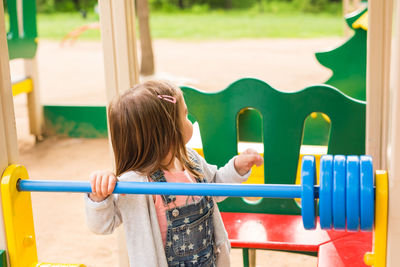 Rear view of girl playing in playground