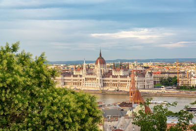 View of buildings in city against cloudy sky
