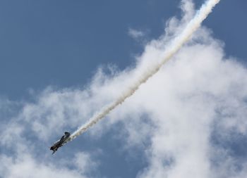 Low angle view of airplane in sky during airshow