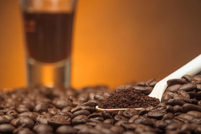 Close-up of ground coffee in the spoon over coffee beans