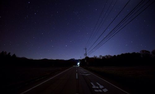 Road against clear sky at night