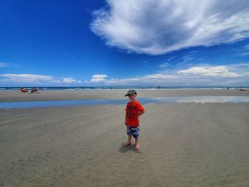 Boy on beach against sky