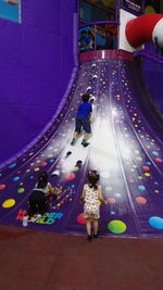 Rear view of people walking on illuminated floor