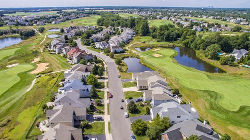 High angle view of golf course in city against sky