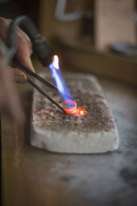 Close-up of hand holding burning candle