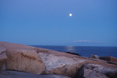 Scenic view of sea against blue sky at night